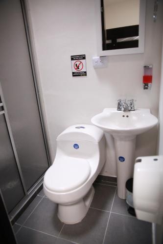 a bathroom with a toilet and a sink at Hotel Madeira in Manizales