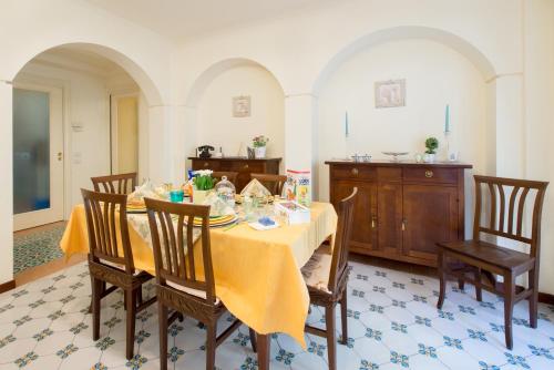 uma sala de jantar com mesa e cadeiras em Art de vivre em Sorrento