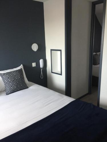 a bedroom with a bed and a phone on the wall at Hotel Ar Terra Nova in Saint Malo
