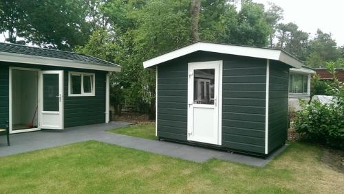 a green shed with a white door in a yard at Dolfijn in Ermelo