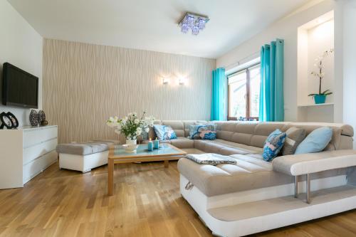 a living room with a couch and a table at VIP Apartamenty Carmelove in Zakopane