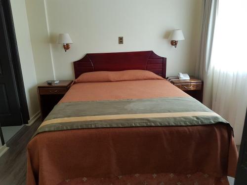 1 cama en un dormitorio con 2 mesitas de noche y ventana en Hotel Diego de Almagro Antofagasta Express, en Antofagasta