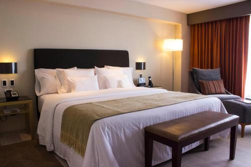 a hotel room with a large bed and a chair at Casa Andina Premium Golf Los Incas in Lima