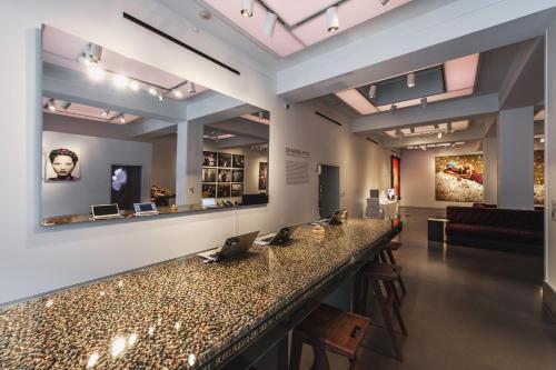 a lobby with a bar with chairs and a couch at 21c Museum Hotel Cincinnati in Cincinnati