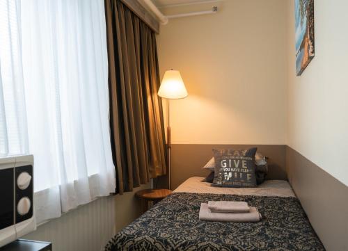a hotel room with a bed with two towels on it at Gasthaus Patruuna in Joutseno