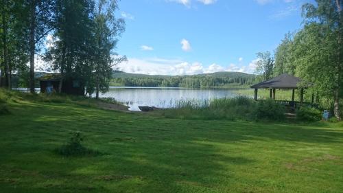 a gazebo in a field next to a lake at Ängsliden in Charlottenberg