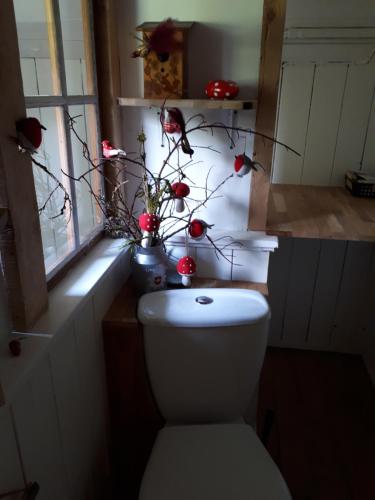 a bathroom with a toilet with a vase with flowers on it at Chalet Chic in Wildhaus