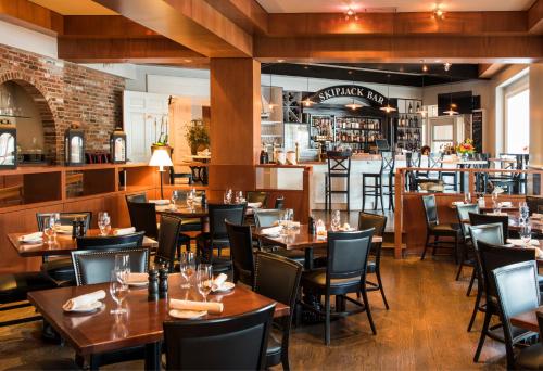 un restaurante con mesas y sillas de madera y un bar en The Tidewater Inn, en Easton
