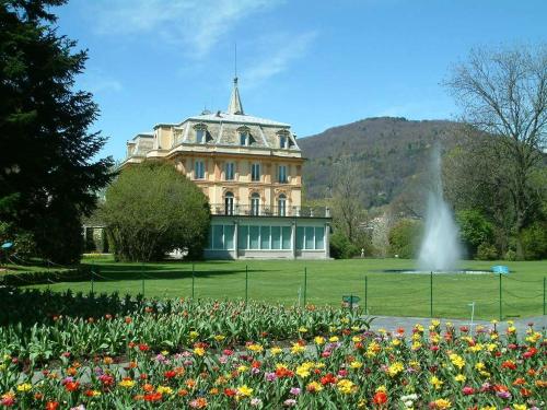 a building with a fountain in front of a field of flowers at Ca' Mea in Baveno