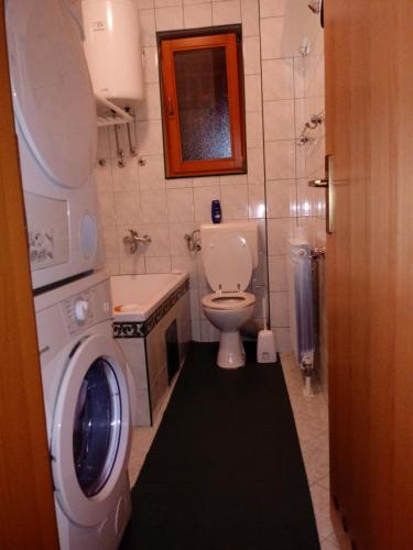 a bathroom with a toilet and a washing machine at Apartments Stan in Sarajevo