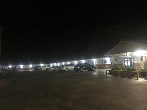 a building with cars parked in a parking lot at night at Classic Inn in Eufaula
