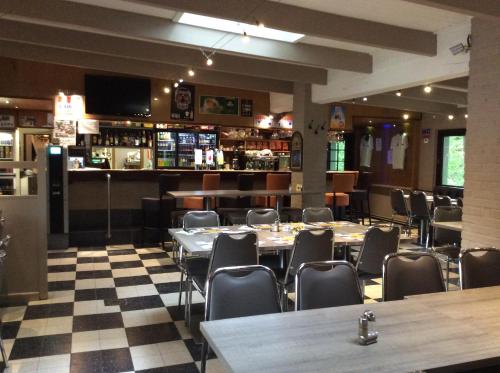 een restaurant met tafels en stoelen en een bar bij Dortoirs Le Domaine in Bilstain