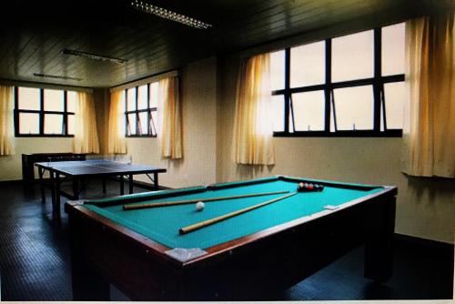 a billiard room with a pool table and two tables at Serema Palace Hotel in Lavras