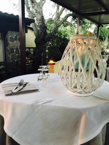 a table with a white table cloth and a vase on it at Il Nuraghe del lago Coghinas in Oschiri