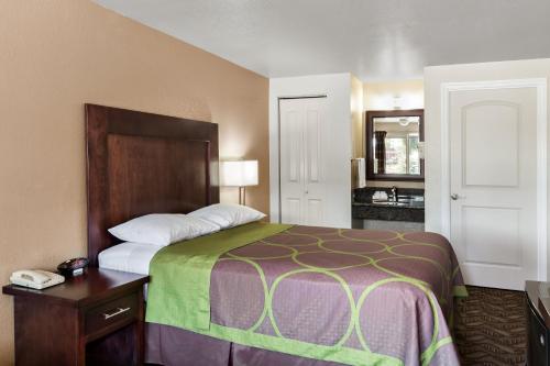 - une chambre d'hôtel avec un lit et un miroir dans l'établissement Budget Lodge Eugene - Airport, à Eugene