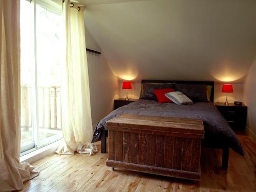 a bedroom with a bed and a large window at La Maison jaune de Chute-Saint-Philippe in Lac-Saint-Paul