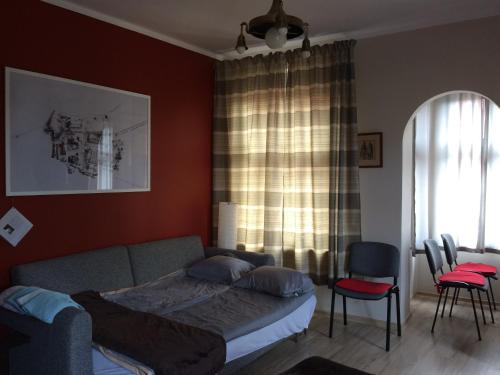 トルンにあるApt nr 2 - cogito.home - Toruń Old Townのベッドルーム(ベッド1台、ソファ、椅子付)