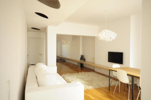 uma sala de estar com um sofá branco e uma mesa em Architectural City Loft em Sófia