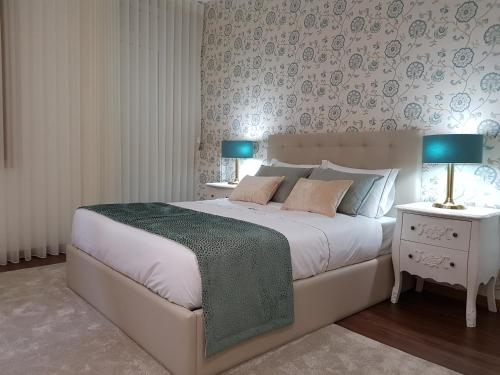 a bedroom with a large white bed with two night stands at 22 Oporto Guesthouse in Porto