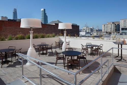 a group of tables and chairs on a rooftop with a city at Hotel Via in San Francisco