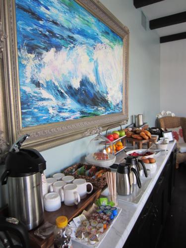 a table with food and a painting on the wall at Hotel Marisol Coronado in San Diego
