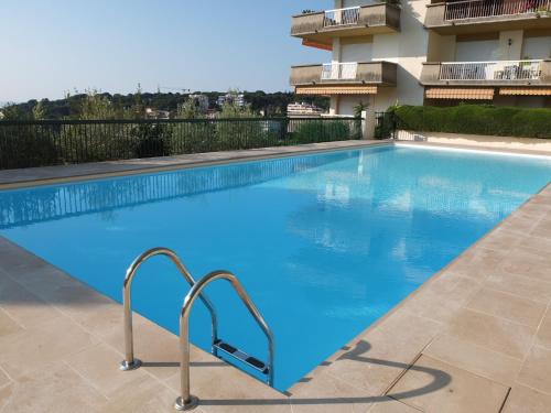 a swimming pool with blue water in a building at Appartement Le Belvédère in Roquebrune-Cap-Martin