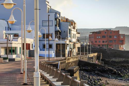 a group of buildings and street lights on a pier at Casa Playa Ondina in Gáldar