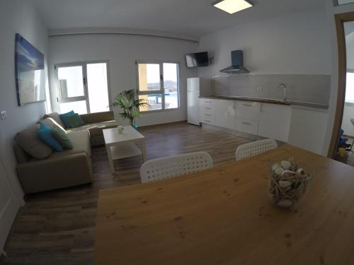 a kitchen and living room with a table and a couch at Casa Playa Ondina in Gáldar