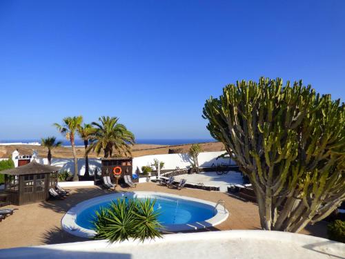 a pool in the middle of a resort with palm trees at Casa Berriel 1 in Tías