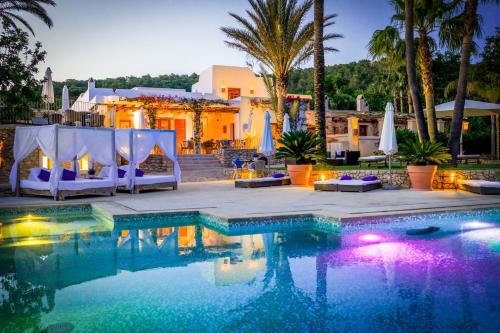uma piscina com cadeiras e uma casa ao fundo em Can Lluc Hotel Rural em Sant Rafael de Sa Creu