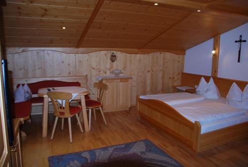 sypialnia z 2 łóżkami i stołem oraz jadalnia w obiekcie Rosumerhof w mieście Leutasch
