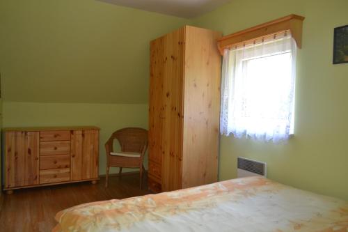 a bedroom with a bed and a dresser and a window at Chaty pod Knížecí, Trojanovice in Trojanovice
