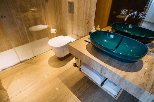 a bathroom with a toilet, sink and tub at Casa do Rio charm suites in Vila do Conde