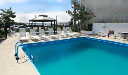 una piscina con sedie e gazebo di Mayfair Hotel a Belmar