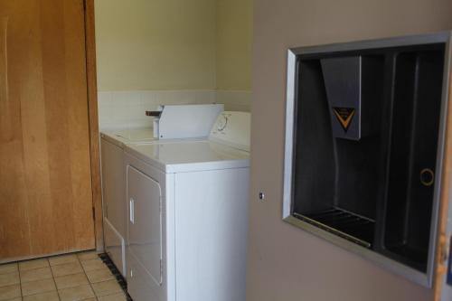 a laundry room with a washer and dryer next to a door at Budget Host Inn Fridley in Fridley