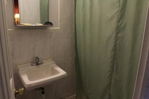 a bathroom with a sink and a shower curtain at Budget Host Inn Fridley in Fridley