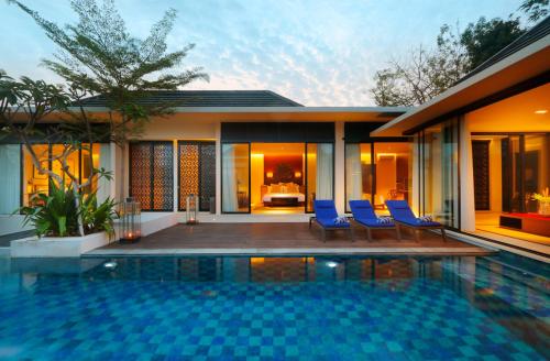 una casa con piscina frente a una casa en Vinila Villas by Nakula, en Nusa Dua