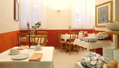 un comedor con mesas, sillas y platos en Atlantide Hotel, en Venecia