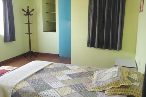 1 dormitorio con 1 cama con una cruz en la pared en Sat Nam Room, en Lima