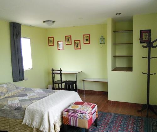 Un dormitorio con una cama y una mesa. en Sat Nam Room, en Lima