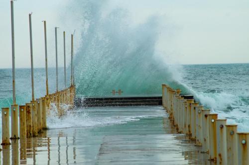 a wave crashing on a pier in the ocean at Loft in Arcadia in Odesa