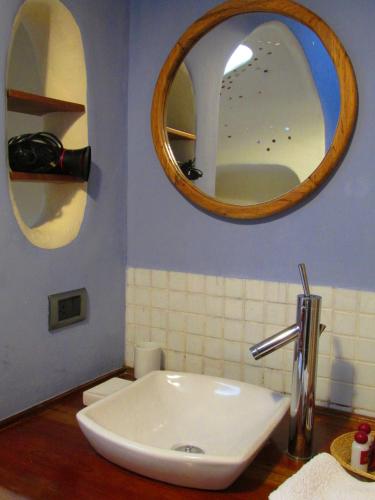 a bathroom with a white sink and two mirrors at Quinua Boutique Apartments in Cusco
