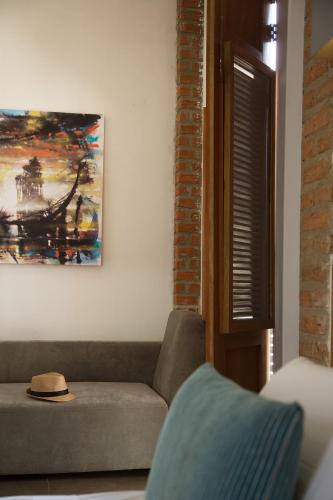 a living room with a couch and a painting on the wall at Hotel Boutique Casa Carolina in Santa Marta
