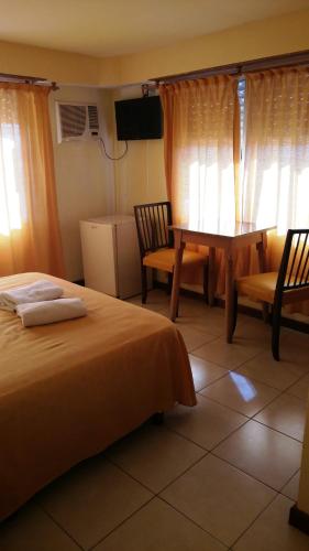 a bedroom with a bed and a table and chairs at San Remo World Hotel in San Clemente del Tuyú