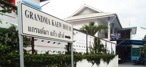 a white street sign in front of a building at Grandma Kaew House in Chiang Rai