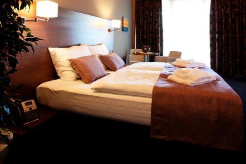 a bed in a hotel room with towels on it at Bohinj Eco Hotel in Bohinj