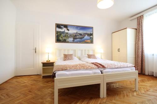 1 dormitorio con 1 cama y una pintura en la pared en Villa Gallistl en Český Krumlov
