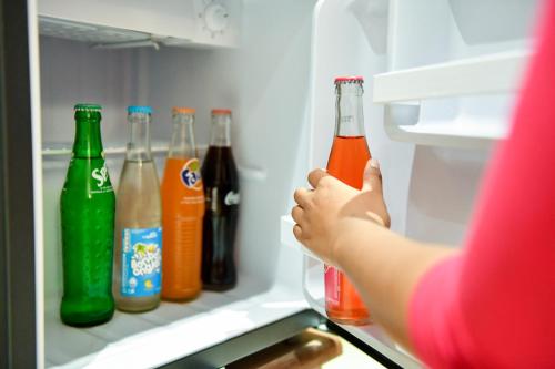 a woman is standing in an open refrigerator at Anjary Hotel Antananarivo in Antananarivo