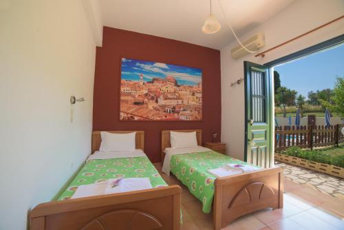 シダリにあるOthonas Apartmentsのベッドルーム1室(ベッド2台付)が備わります。壁には絵画が飾られています。