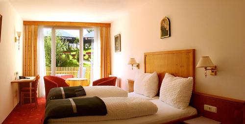 a hotel room with a bed and a balcony at Hotel Stolz in Matrei am Brenner